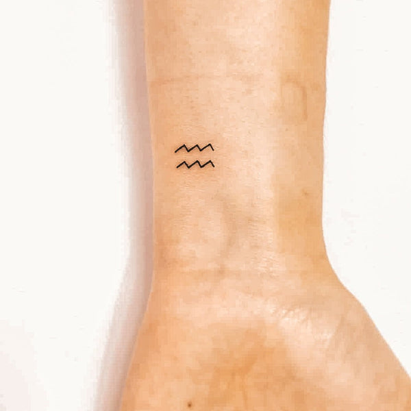Aquarius zodiac symbol tattoo on the wrist